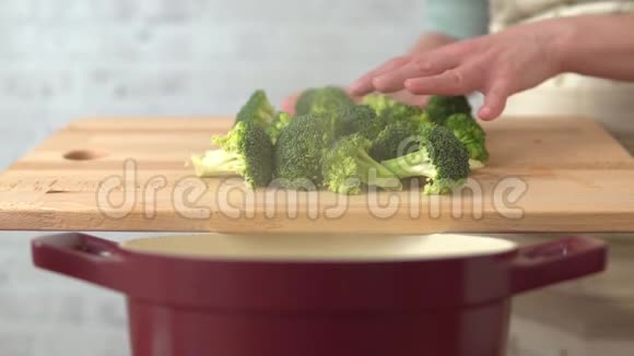 女人在厨房里煮西兰花视频的预览图