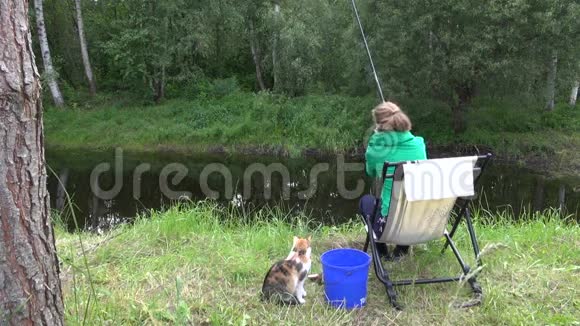 女人在农村池塘里钓鲤鱼饿猫等鱼视频的预览图