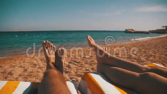 情侣腿躺在红海边的沙滩太阳休息室视频的预览图