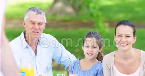 一家人在公园里看爸爸烤汉堡视频的预览图
