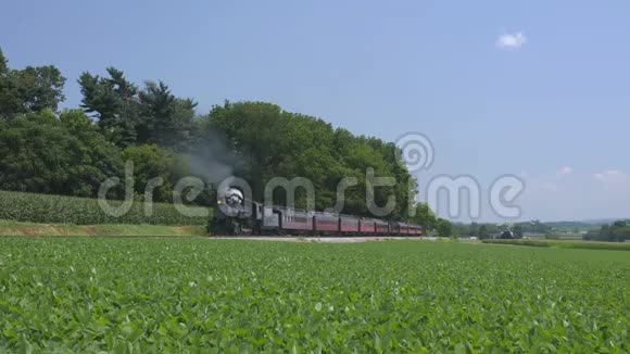 一台1924年蒸汽机乘火车喷出烟雾沿着阿米什农村行驶视频的预览图