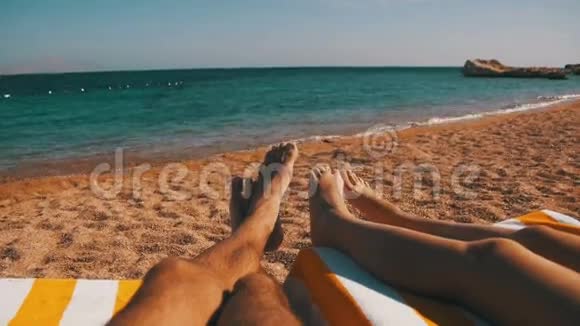 情侣腿躺在红海边的沙滩太阳休息室视频的预览图