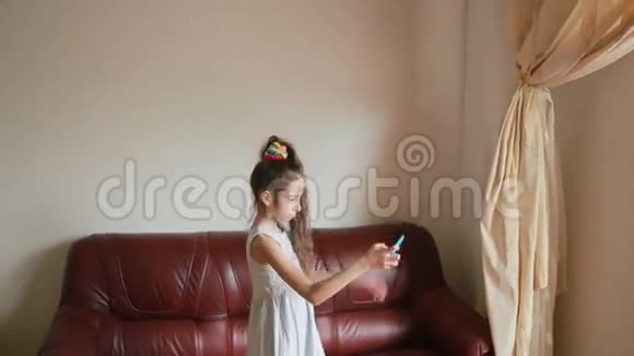 小女孩在家里沙发上用智能手机自拍视频的预览图