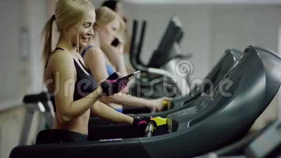 在跑步机上行走的女人在打电话视频的预览图