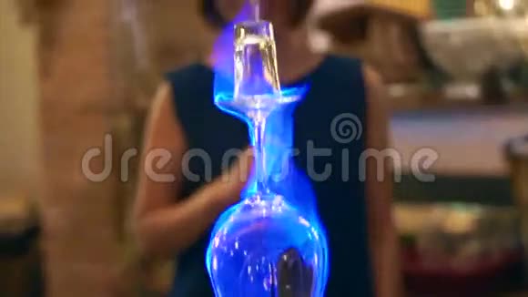视频浇注和喝燃烧的酒精鸡尾酒蓝色烧制鸡尾酒玻璃视频的预览图
