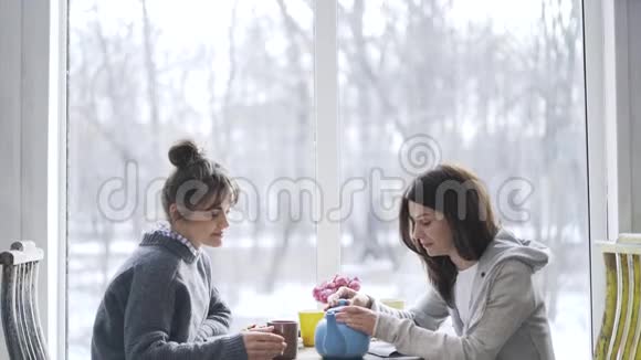 两个年轻女人在咖啡馆喝茶视频的预览图