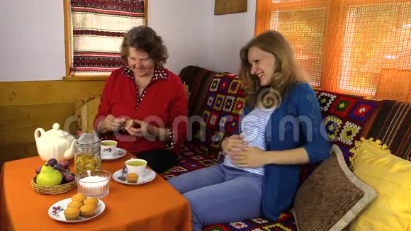 老妇人和怀孕的孙女用茶吃糖果视频的预览图
