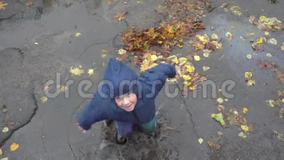 小男孩在泥泞的水坑里跳慢动作250英尺视频的预览图