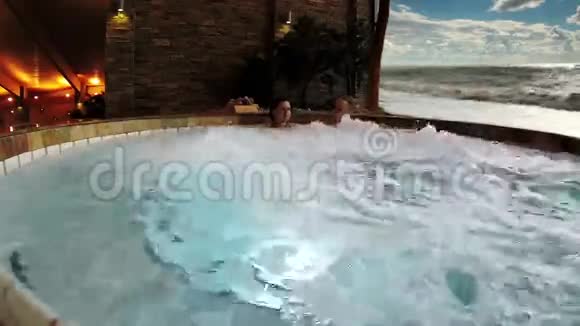 带按摩浴缸的年轻夫妇在热带温泉度假村视频的预览图