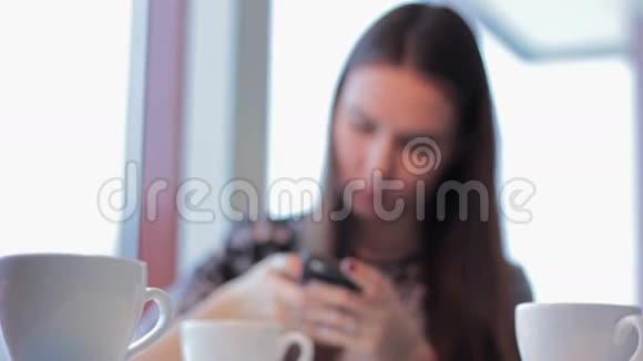 有智能手机的女人在咖啡厅喝拿铁视频的预览图