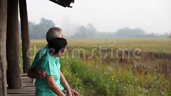 视频亚洲资深情侣坐在稻田旁的凉亭里农业和农业企业视频的预览图