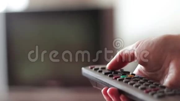 人的手改变电视遥控器上的频道视频的预览图