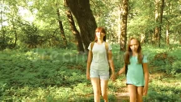 徒步旅行的快乐女孩旅行者带着背包去森林里远足的女人在森林里散步夏天快乐的徒步旅行者女孩视频的预览图