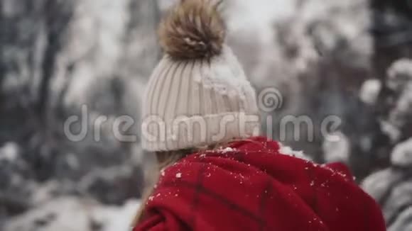 年轻漂亮的女孩穿着暖和的衣服走在圣诞树附近慢动作年轻时尚的肖像视频的预览图