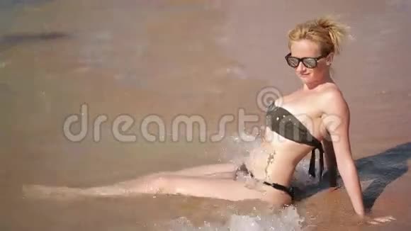 在沙滩上躺在水里的女孩暑假休息视频的预览图