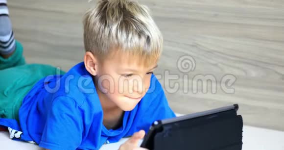 小男孩在平板电脑上玩视频的预览图