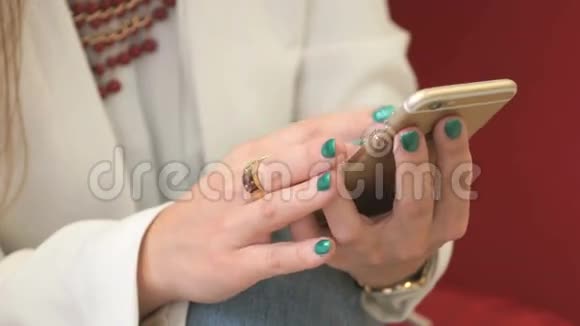 女性手使用黄金智能手机特写镜头视频的预览图