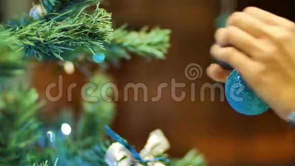 女人的手在圣诞树上挂球寒假圣诞节和新年装饰闪烁的加兰视频的预览图