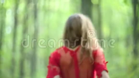 美丽的女人穿过绿色森林视频的预览图