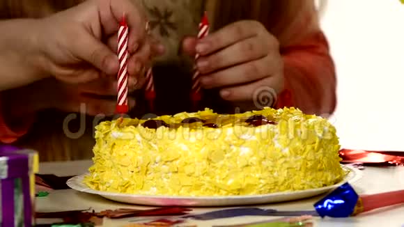 孩子们把蜡烛放在生日蛋糕里视频的预览图