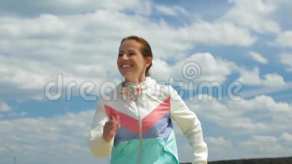微笑的女人沿着海滩奔跑视频的预览图