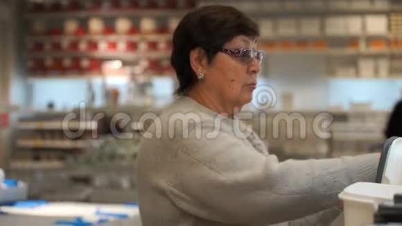 商店里买塑料食品容器的女人视频的预览图