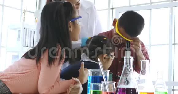 在实验室里男孩透过显微镜看视频的预览图