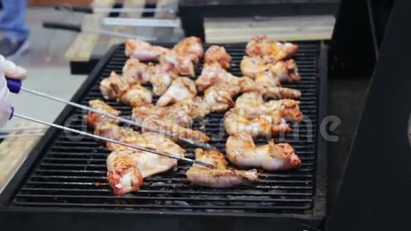 在烧烤架上翻过来的鸡肉翅膀肉是用芒果烧烤架炒的烤架上的鸡肉视频的预览图