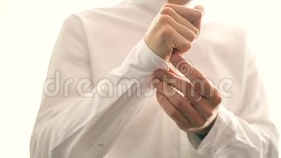 一位新郎穿着正式服装戴上袖扣视频的预览图