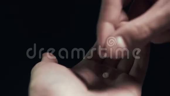 手中的药丸和一杯水隔离的黑色背景男人服用药丸视频的预览图
