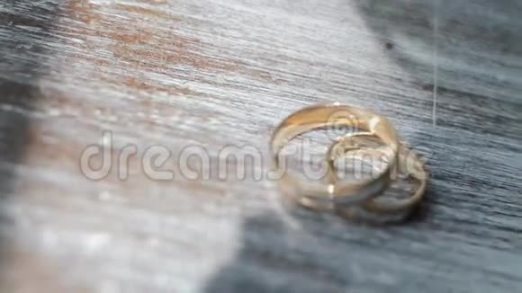 餐桌上的金色结婚戒指视频的预览图