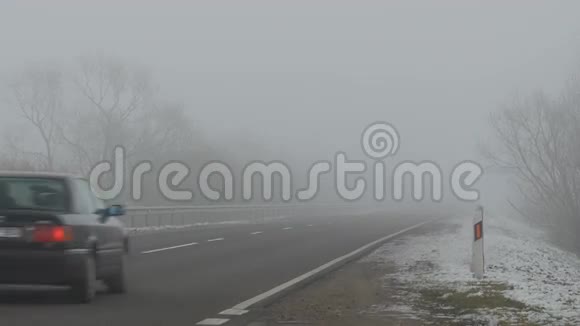 汽车在路上行驶在雾中闪耀着灯光视频的预览图
