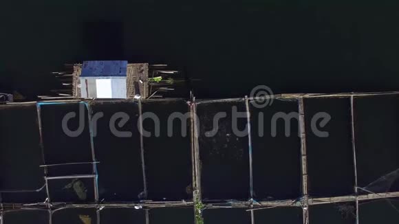 渔夫在山湖上的竹笼里喂鱼空中打击视频的预览图