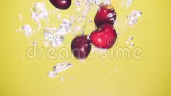 一颗新鲜的樱桃在黄色的背景上溅入水中视频的预览图