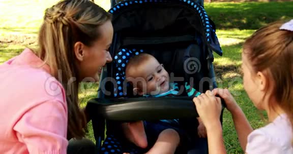 妈妈和女儿在公园里玩婴儿车视频的预览图