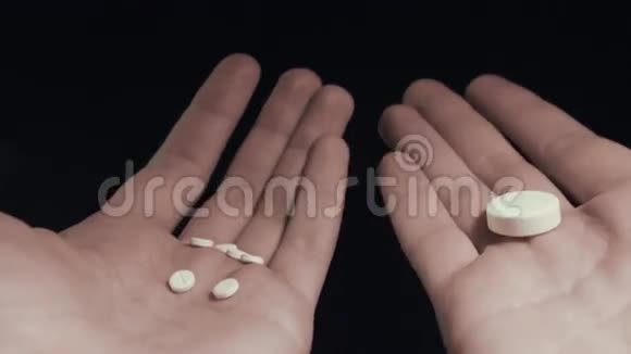 一个人在几颗小药丸和一颗大药丸之间选择把它们全吃了视频的预览图