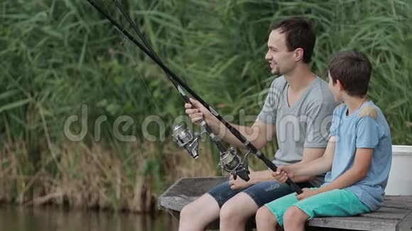 积极的父子在池塘边钓鱼视频的预览图