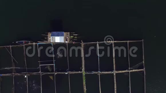 渔夫在山湖上的竹笼里喂鱼空中打击视频的预览图
