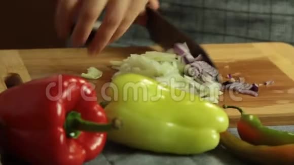 女人切洋葱和红胡椒煮红薯玉米饼视频的预览图