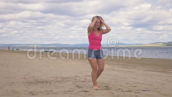 快乐的年轻女子在蓝色的海水中在热带海滩跳舞视频的预览图