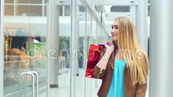 美丽的金发女郎去商店购物慢点视频的预览图