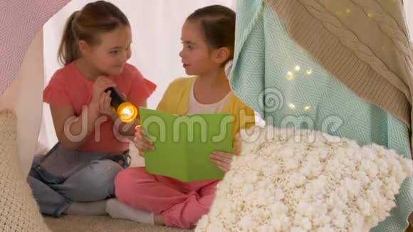 快乐女孩在家的孩子帐篷里看书视频的预览图