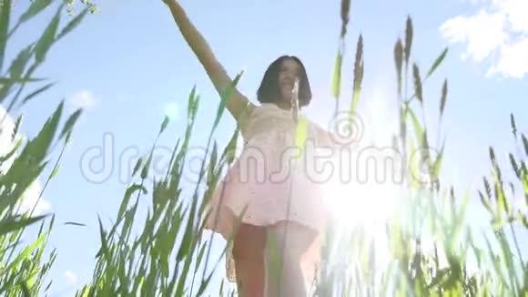 穿着裙子的女孩在绿草地上女孩的生活方式阳光灿烂夏日快乐视频的预览图