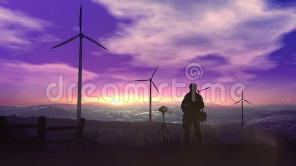 高耸在夕阳下的风力发电厂的剪影视频的预览图