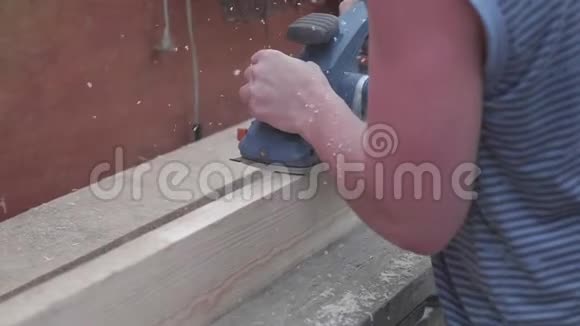 人建设者用电动工具在工作台上工作用木头做的物体的构造木板加工视频的预览图