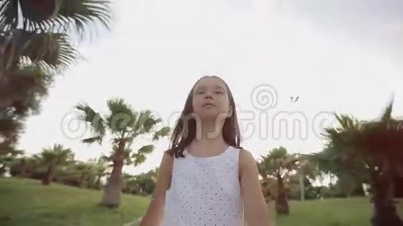 日落时分孩子走过一条棕榈胡同欢乐和歌唱视频的预览图