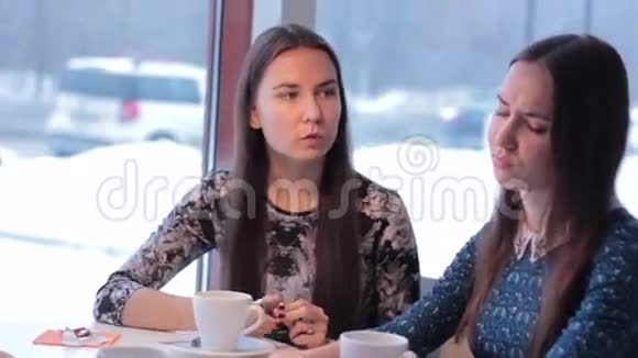 两个微笑的女朋友喝咖啡交流视频的预览图