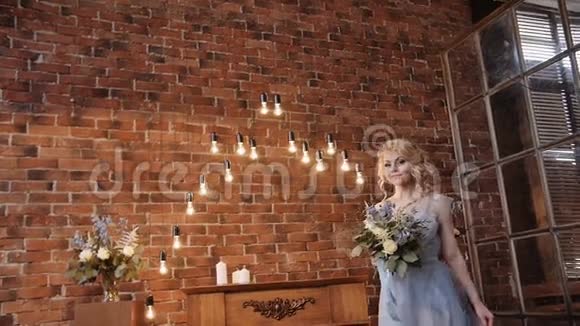 新娘穿着时尚宁静的连衣裙在阁楼的空间里有一束花视频的预览图