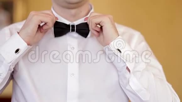 男人穿白色衬衫系蝴蝶结视频的预览图