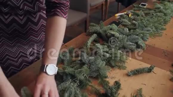 工作中的花商女人用手制作圣诞装饰花环新年快乐大餐视频的预览图